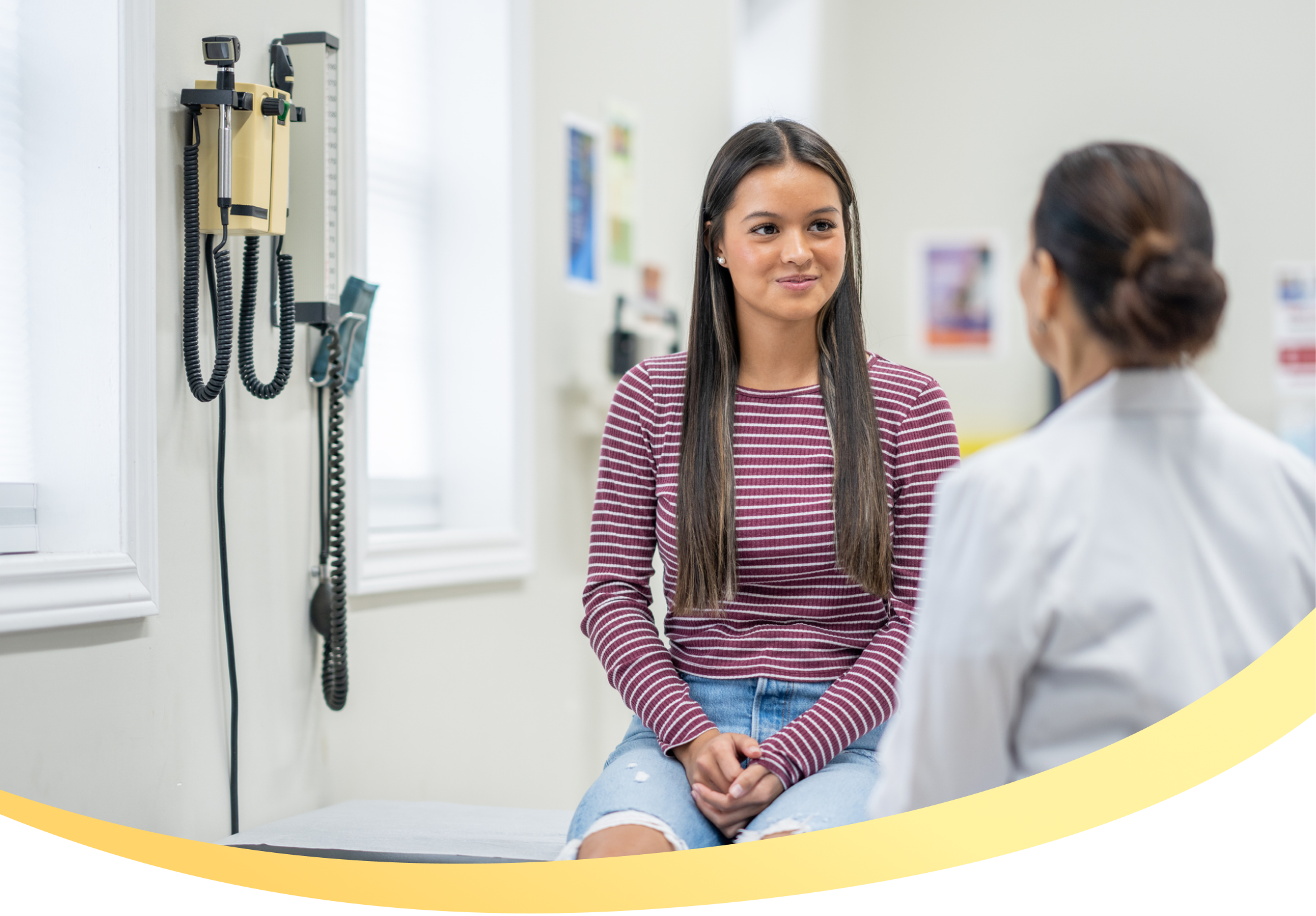 Teen girl in a doctors office speaking with a female doctor
